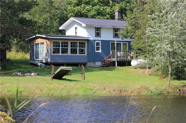 back of property featuring a lawn and a water view