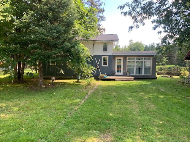 rear view of house with a deck and a lawn