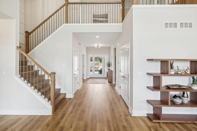 foyer entrance with a high ceiling and wood-type flooring