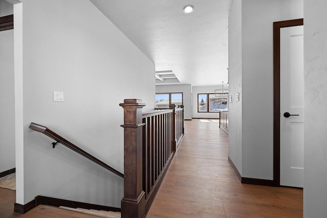 hall featuring light hardwood / wood-style flooring and a notable chandelier