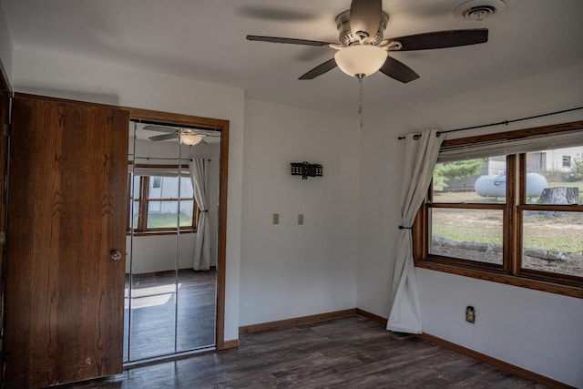 unfurnished bedroom with dark wood-type flooring, a closet, and ceiling fan