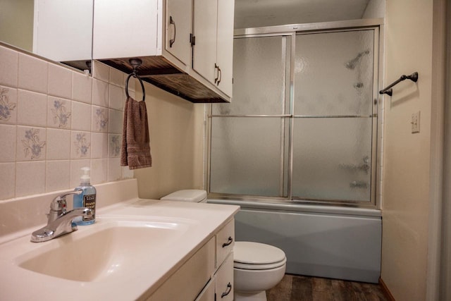 full bathroom featuring toilet, shower / bath combination with glass door, vanity, tasteful backsplash, and hardwood / wood-style flooring