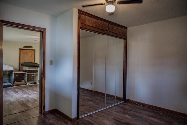 bedroom with a textured ceiling, ceiling fan, a closet, and dark hardwood / wood-style flooring