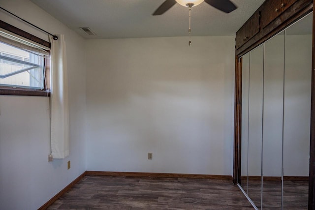 unfurnished bedroom with a closet, a textured ceiling, ceiling fan, and dark hardwood / wood-style floors