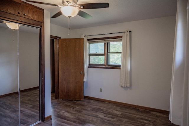 unfurnished bedroom featuring a textured ceiling, dark wood-type flooring, ceiling fan, and a closet