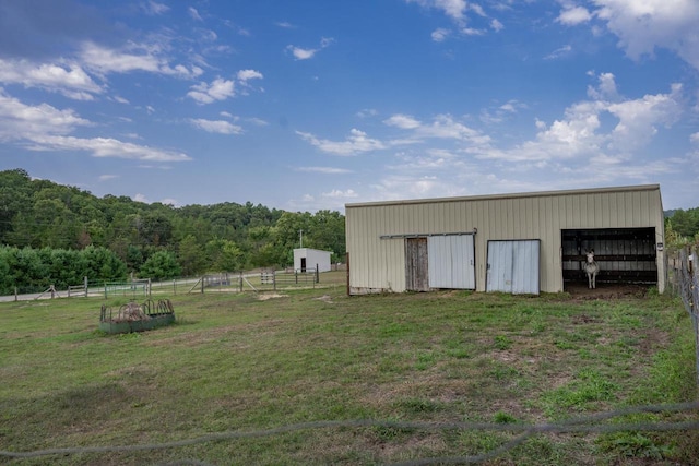 view of outbuilding featuring a lawn and a rural view