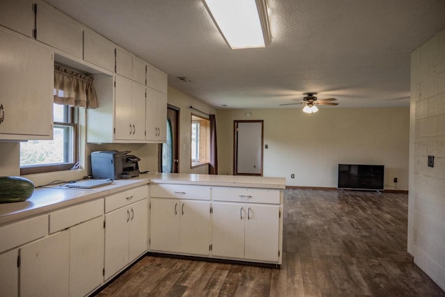 kitchen with white cabinetry, dark hardwood / wood-style floors, kitchen peninsula, ceiling fan, and a textured ceiling