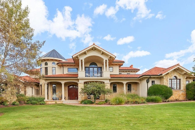 mediterranean / spanish-style home featuring a balcony and a front yard