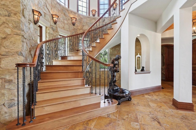 stairway featuring a towering ceiling