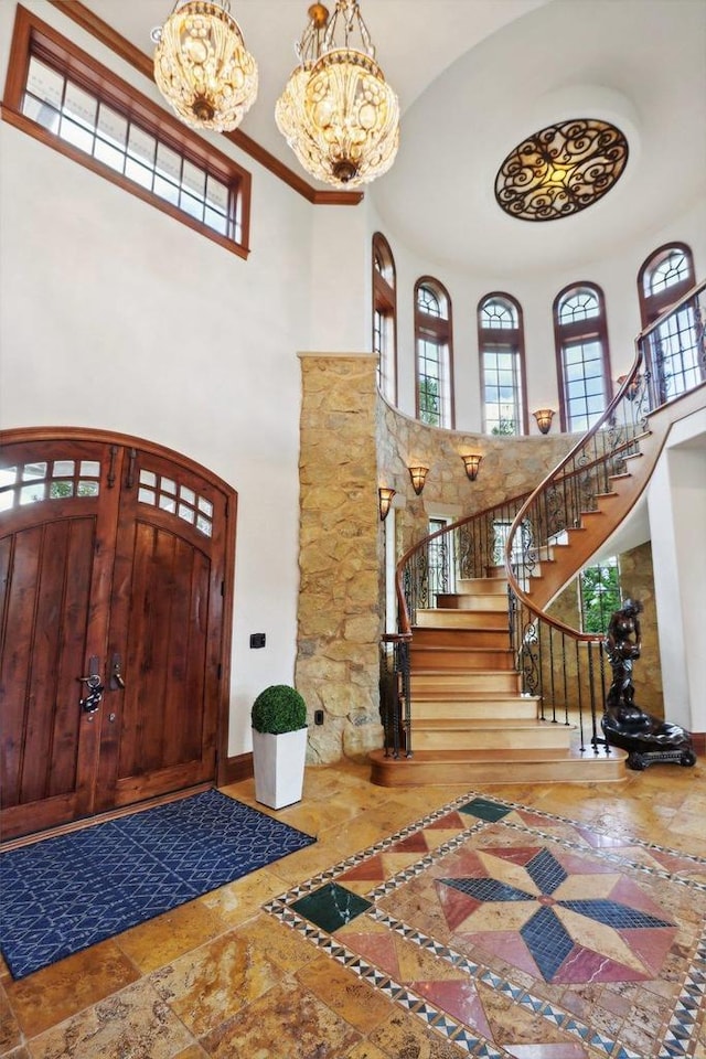 foyer featuring an inviting chandelier and a towering ceiling