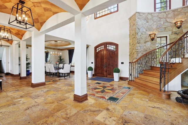 entrance foyer with a chandelier, a high ceiling, and a healthy amount of sunlight