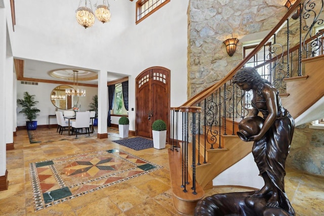 foyer with a towering ceiling and a chandelier