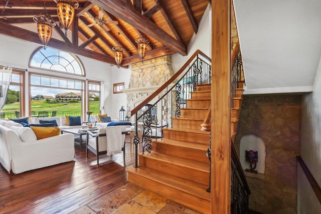 stairway featuring high vaulted ceiling, hardwood / wood-style floors, a chandelier, wooden ceiling, and beam ceiling