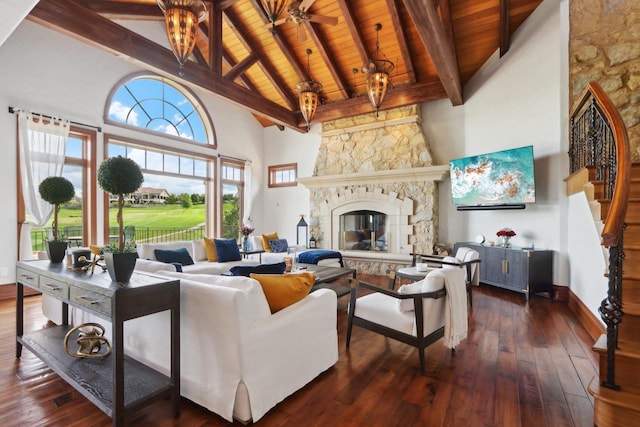 living room with dark wood-type flooring, ceiling fan, a fireplace, and wooden ceiling