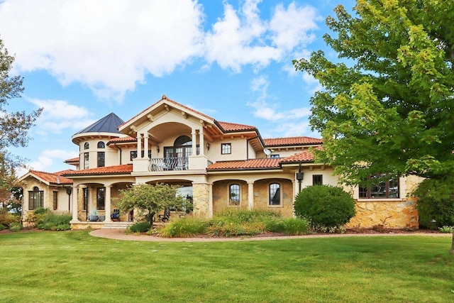 mediterranean / spanish-style home featuring a balcony and a front yard