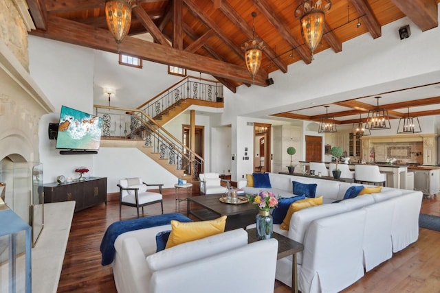 living room featuring high vaulted ceiling, hardwood / wood-style floors, an inviting chandelier, wooden ceiling, and beam ceiling