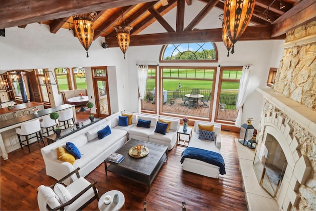 living room with a fireplace, high vaulted ceiling, and an inviting chandelier