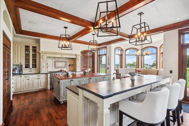 kitchen featuring a center island, pendant lighting, cream cabinetry, and dark wood-type flooring