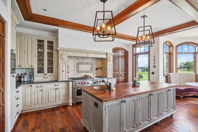 kitchen with wooden counters, decorative light fixtures, a notable chandelier, and dark wood-type flooring