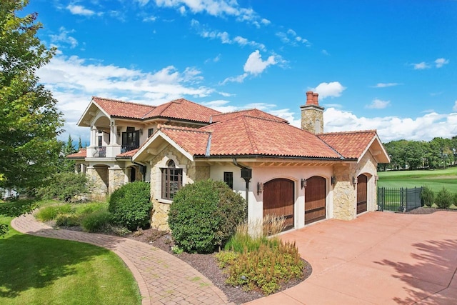 mediterranean / spanish house with a balcony, a front yard, and a garage