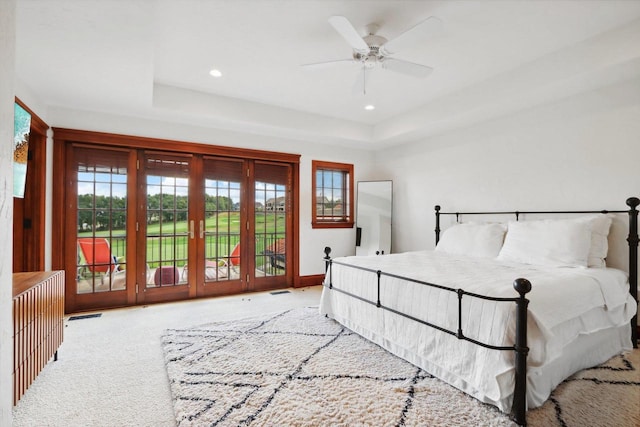 bedroom with multiple windows, ceiling fan, light colored carpet, and access to exterior