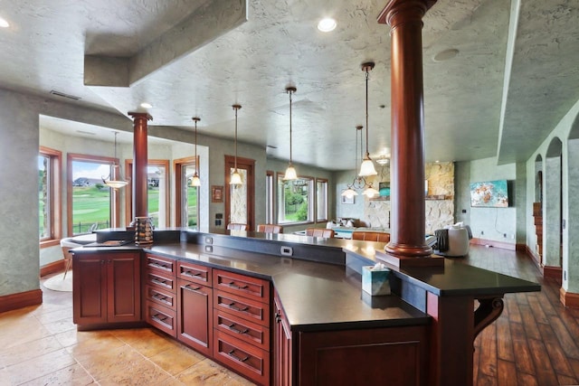 kitchen featuring decorative columns and hanging light fixtures