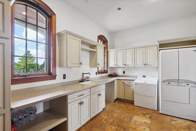 kitchen featuring washing machine and clothes dryer and sink