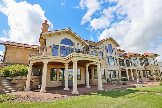 back of property featuring a balcony and a patio