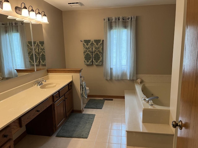 bathroom with tile patterned floors, vanity, tiled tub, and a wealth of natural light