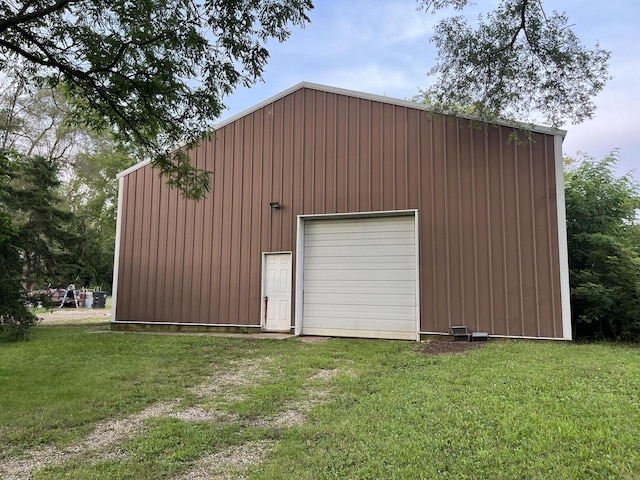 view of outdoor structure featuring a lawn and a garage