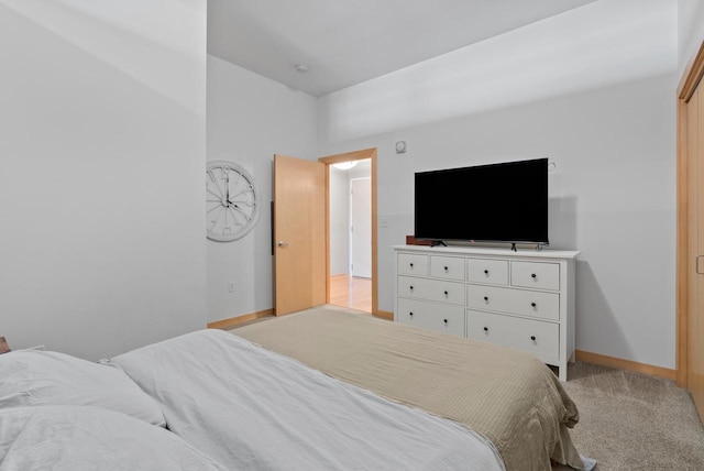 bedroom with light colored carpet and baseboards