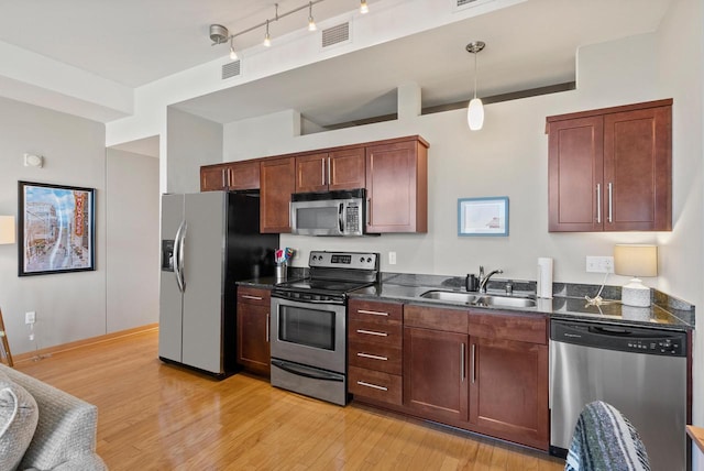 kitchen featuring visible vents, stainless steel appliances, light wood-type flooring, and a sink