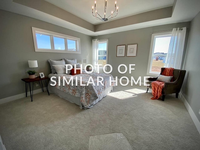 carpeted bedroom with a raised ceiling and a notable chandelier