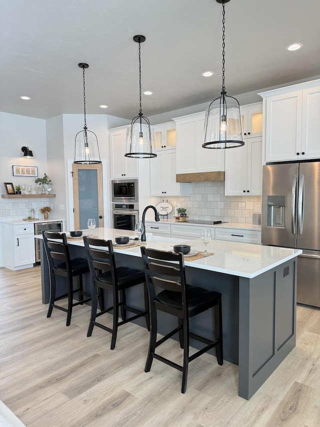 5090 N Cobble Creek Dr, Grand Chute, WI 54913 - kitchen with appliances with stainless steel finishes, tasteful backsplash, a spacious island, white cabinets, and light countertops