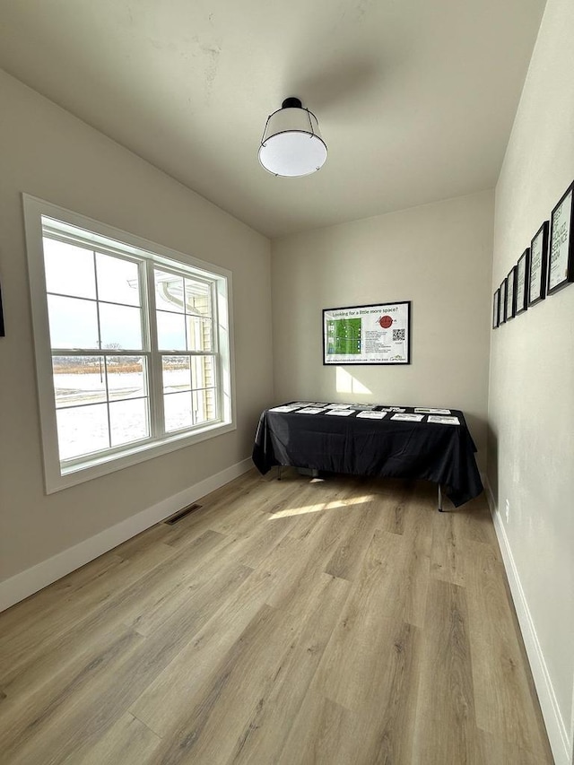 bedroom featuring visible vents, light wood-style flooring, and baseboards