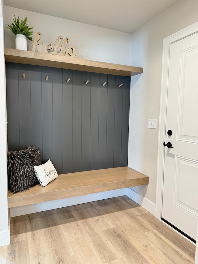 mudroom featuring light wood finished floors and baseboards