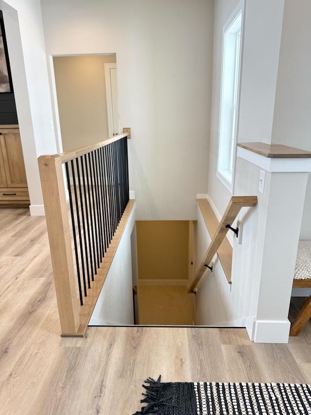 staircase featuring baseboards and wood finished floors