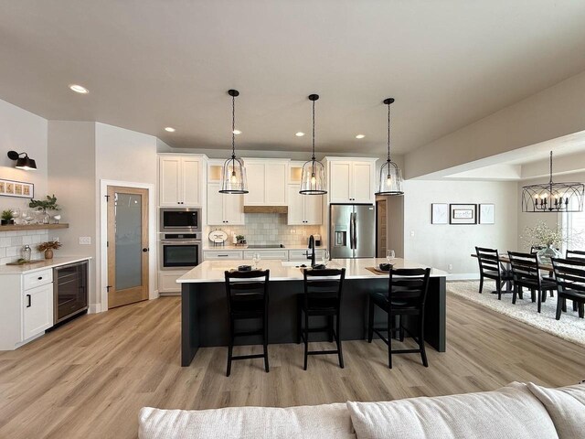 5090 N Cobble Creek Dr, Grand Chute, WI 54913 - kitchen featuring stainless steel appliances, beverage cooler, a kitchen bar, light countertops, and recessed lighting