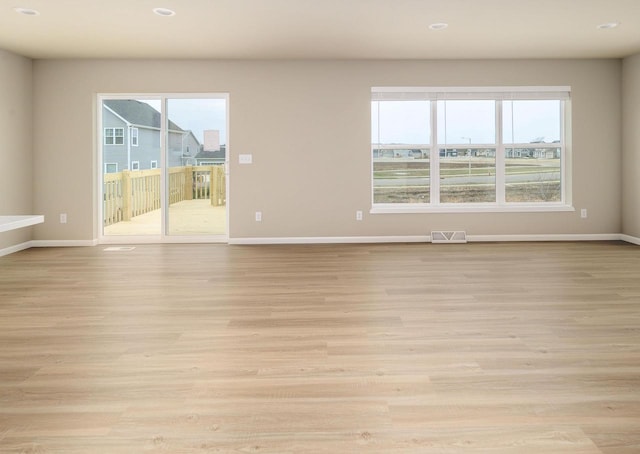 empty room with a healthy amount of sunlight and light wood-type flooring