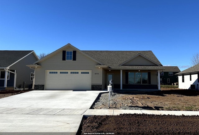 view of front of home featuring brick siding, driveway, a porch, and a garage