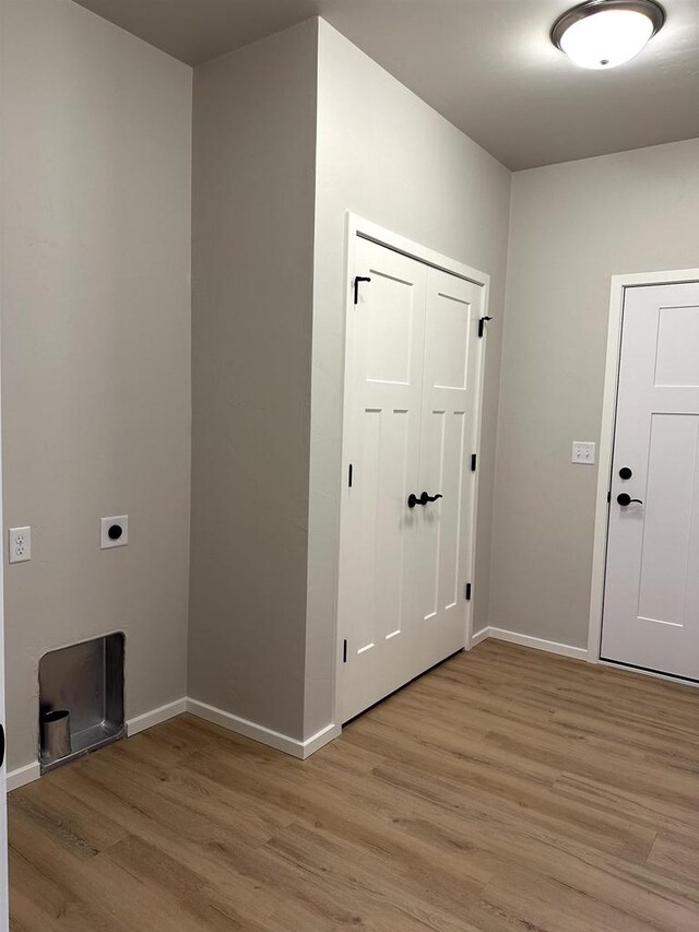 interior space with light wood-style floors, baseboards, and hookup for an electric dryer