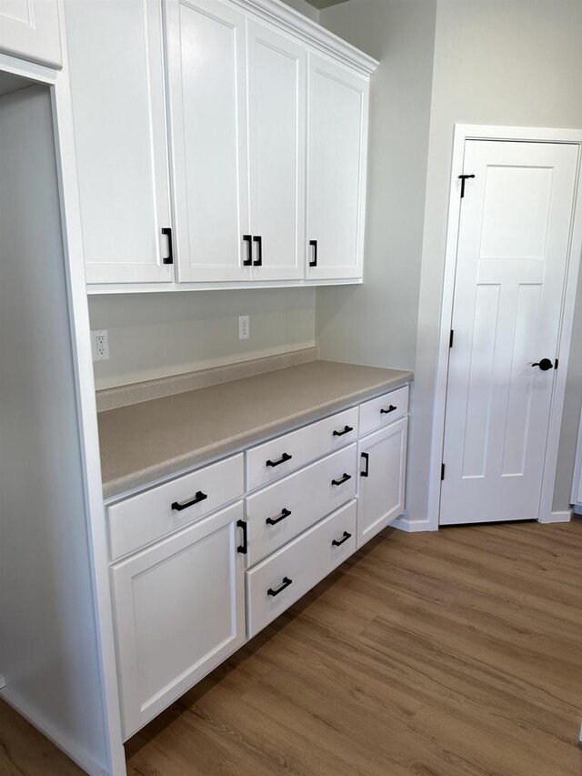 interior space featuring light countertops, white cabinets, and wood finished floors