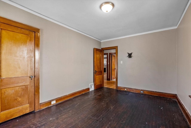 unfurnished room featuring baseboards, hardwood / wood-style floors, and crown molding