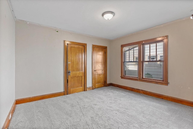 unfurnished room featuring baseboards, carpet floors, and ornamental molding