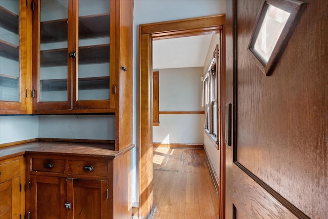 hallway featuring baseboards and light wood-style floors