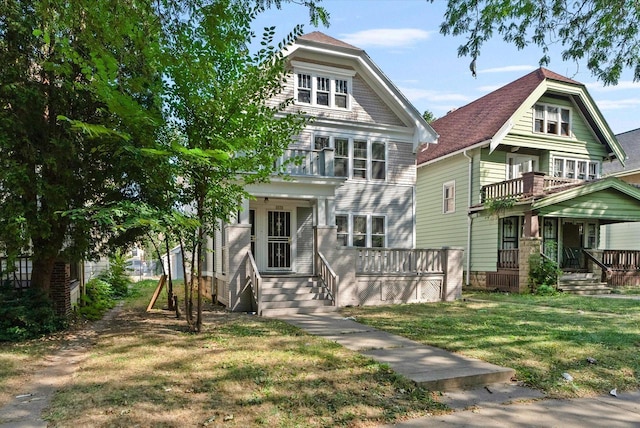 view of front of property with a balcony, a porch, and a front lawn