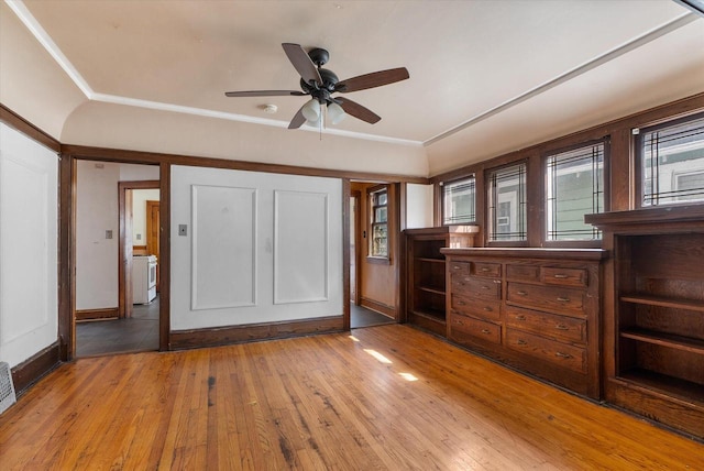 unfurnished bedroom with washer / clothes dryer, light wood-style flooring, and ornamental molding