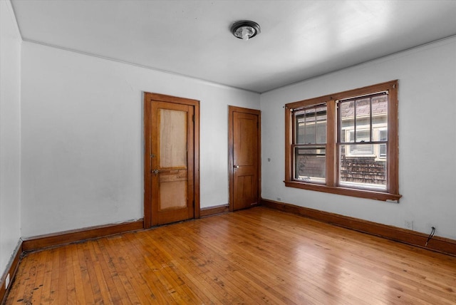 spare room featuring light wood-style floors and baseboards