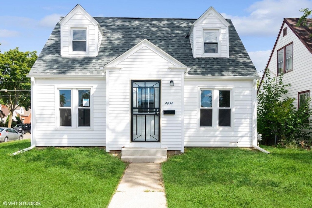 cape cod house with a front yard