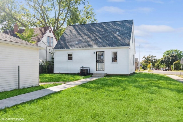 back of house featuring a lawn and central AC unit